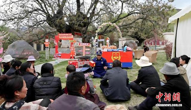 图为消防人员在山南市加查县千年核桃林景区向群众讲解消防安全知识。受访者 供图