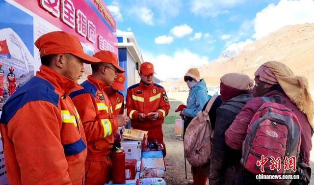 图为阿里消防人员向朝拜信众发放带有消防知识标识的口罩、遮阳帽等。受访者 供图