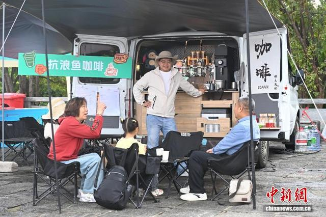 5月1日，游客坐在咖啡车前享受“五一”假日时光。中新社记者 李嘉娴 摄