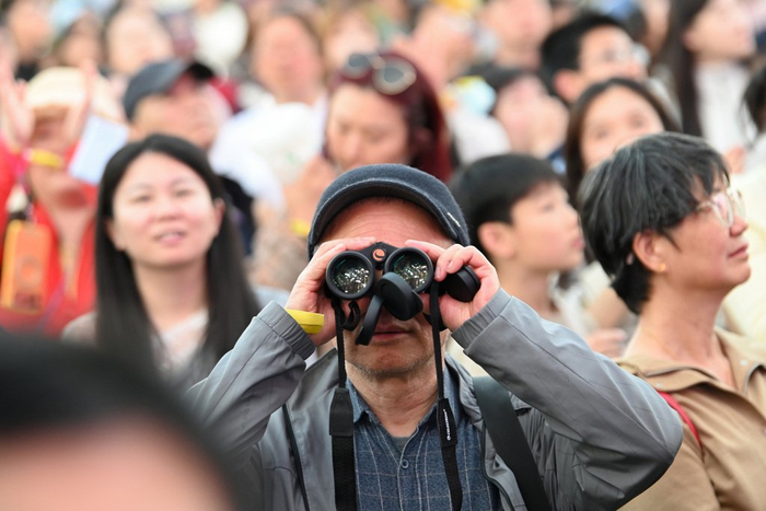 2026年5月1日，上海复兴岛，一位年长的男士用望远镜看演出。澎湃新闻记者 吴栋 图