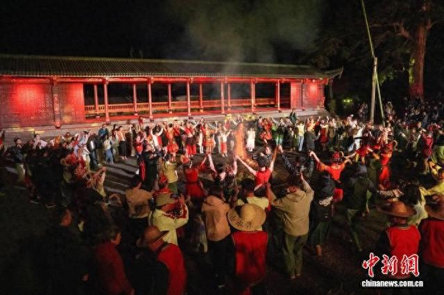身着畲族服饰的村民与游客们手拉手，围着熊熊篝火载歌载舞。陈伟杰 摄
