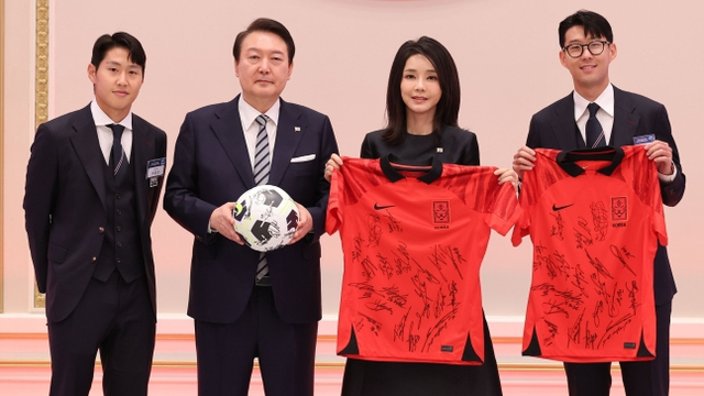 晚宴上，韩国球员孙兴慜（右一）和李刚仁（左一）向尹锡悦夫妇赠送由韩国队队员集体签名的足球和球衣。图自韩媒