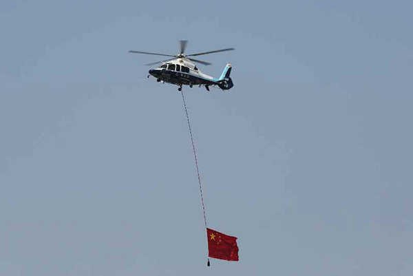 2015年，上海市公安局警务航空队直升机悬挂一面巨幅国旗飞越赛车场上空。
