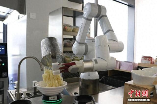 浙江杭州的一家机器人餐厅内，机器人为顾客煮面。吴怡欣 摄