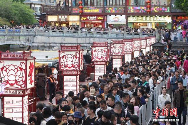 5月3日，江苏南京，游客们在秦淮河畔排队，准备乘坐画舫。“五一”假期，南京旅游景点人气旺。中新社记者 泱波 摄