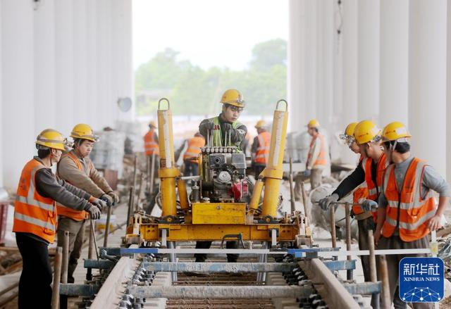 ↑ 5月3日，中铁十一局建设者在浙江省湖州市德清县杭德市域铁路舞阳车辆基地进行轨道组装起道作业。新华社发（谢尚国 摄）