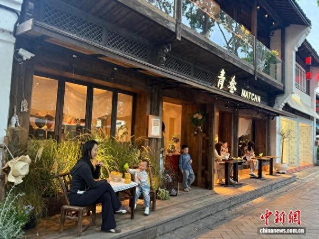 “五一”期间，游客在杭州大兜路一家咖啡店门口打卡拍照。 奚金燕 摄