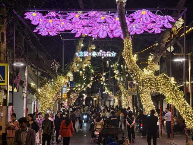 镇江京畿路举办“春日花花会”主题活动，街区装扮一新，夜间游客如织，共赏花灯夜市。邵城/摄
