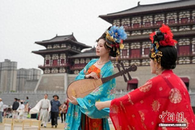 5月1日，游客身穿汉服在位于河南洛阳的隋唐洛阳城应天门遗址博物馆前拍照。 中新社记者 李超庆 摄
