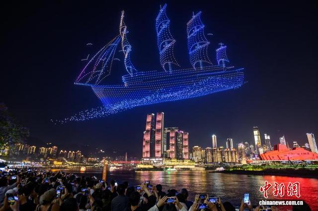 5月4日晚，游客在重庆南滨路观赏无人机灯光秀。中新社记者 何蓬磊 摄