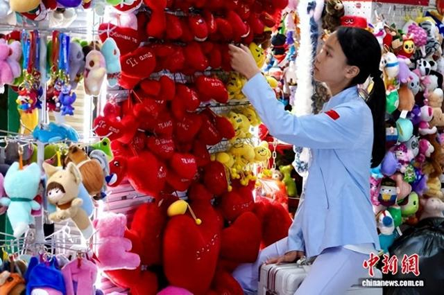 5月1日，林女士的女儿林圆圆坐在行李箱上，选购商品。董易鑫 摄