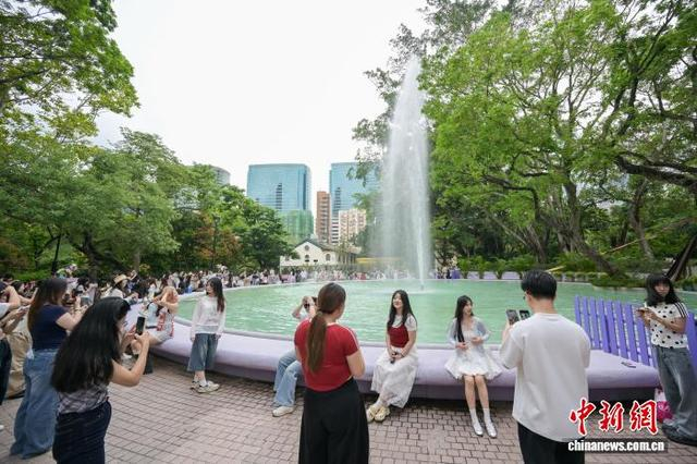 图为大批旅客在九龙公园喷水池前留影。中新网记者 陈永诺 摄