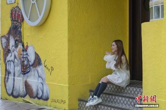 图为一名女士在赤柱与猫咪壁画合影。中新网记者 陈永诺 摄