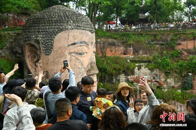 5月1日，“五一”假期首日，位于四川省乐山市三江汇流处的乐山大佛景区，八方游客纷至沓来，共赏大佛雄姿。记者 刘忠俊 摄