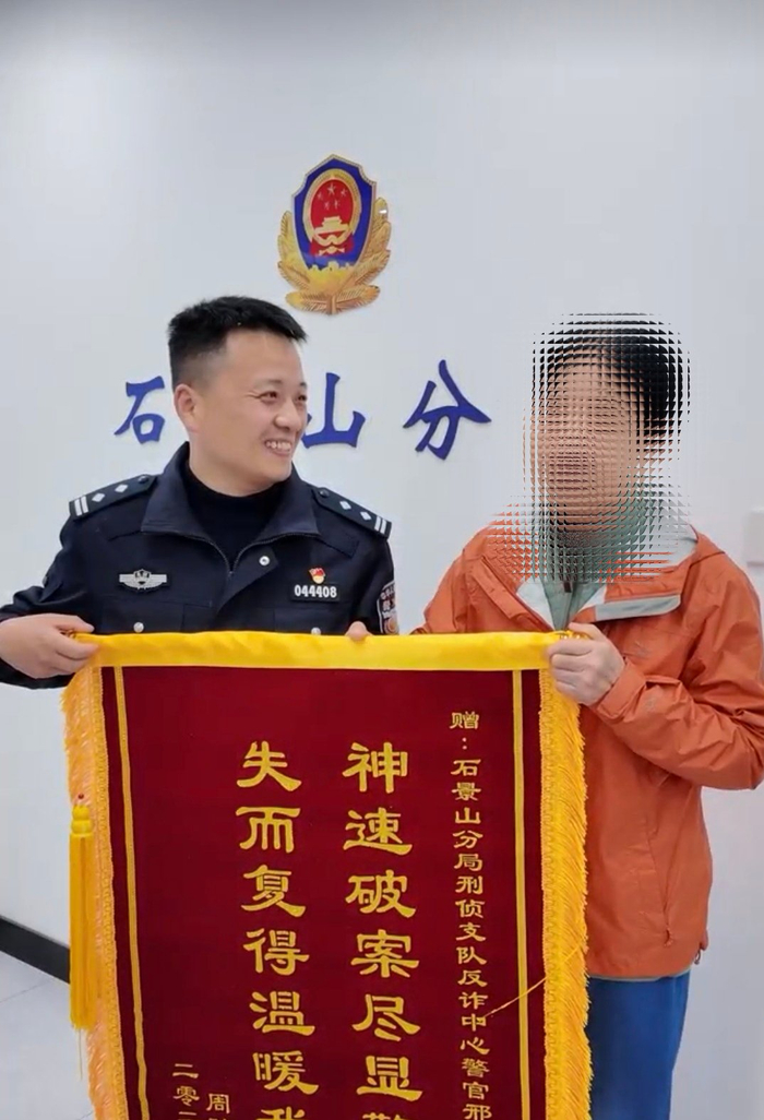 周女士为办案民警邢运伟送来锦旗表达感谢。新京报记者 张静姝 摄