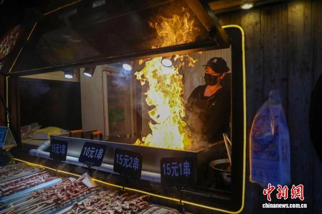图为“不夜街”烧烤摊前，嗞嗞作响的烤串正散发着诱人香气，勾勒出归流河畔浓郁的人间烟火气。 韩双龙 摄