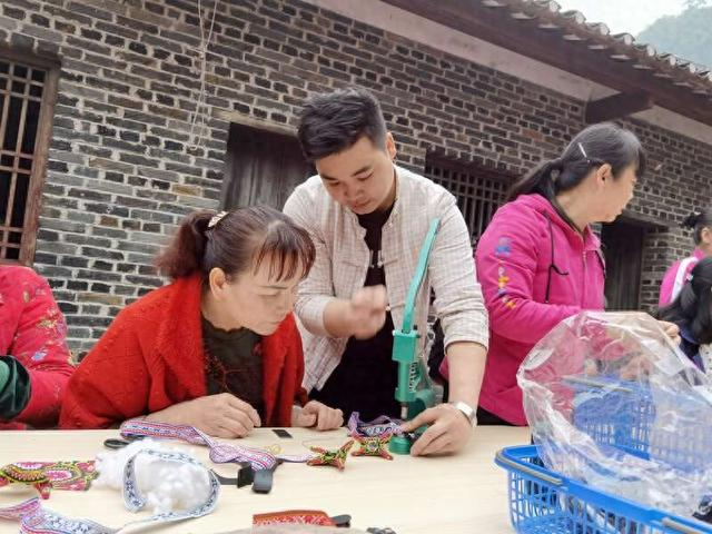 兰培文（左二）对织娘进行技术指导。受访者供图