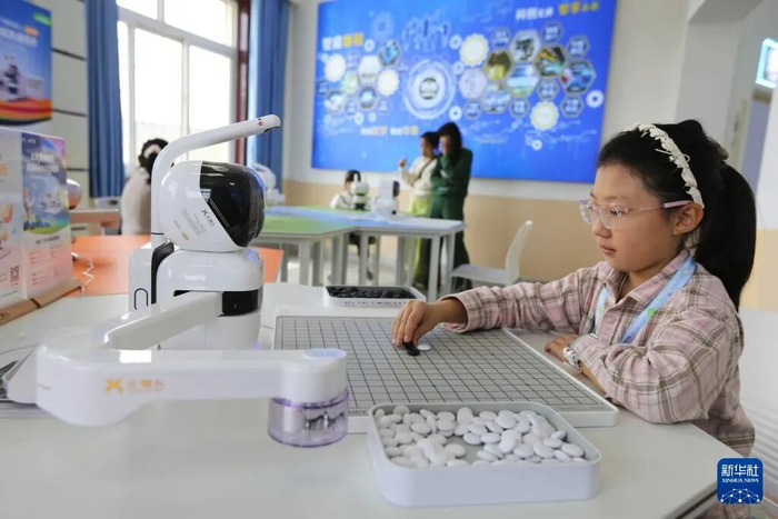 5月7日，学生在甘肃省定西市安定区科技馆和智能机器人对弈。新华社发（王克贤 摄）