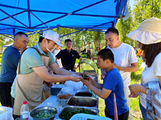 芳草湖凉皮摊位前，游客们排队购买凉皮。史涛 摄