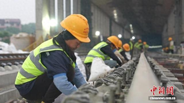 图为昌九高铁无砟轨道混凝土浇筑施工现场，施工人员对轨道钢筋进行捆扎作业。刘述鹏 摄