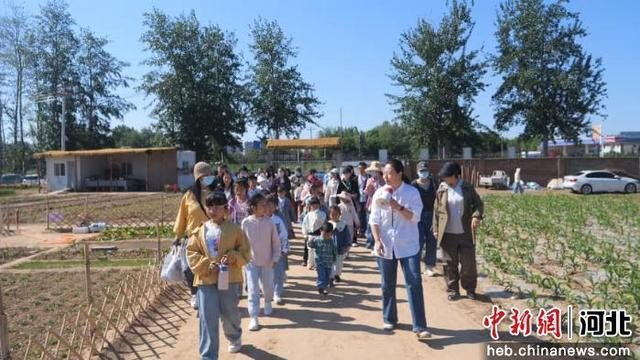 工作人员带领大家参观农场。 范佳浩 摄
