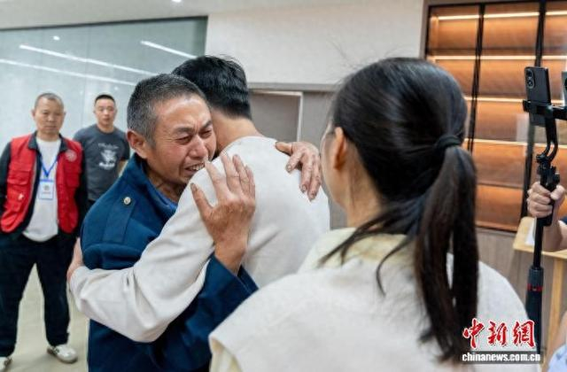 67岁的四川广安男子邓昌华紧紧拥抱着失散35年的儿子。唐超 摄
