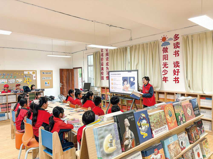 4月22日，在贵州石阡县甘溪红军小学的“知行书屋”里，志愿者正在引导孩子们阅读书籍。新华每日电讯记者李凡摄