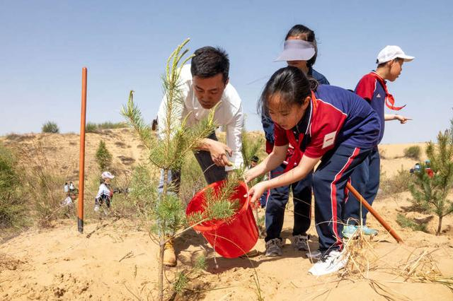 5月9日，内蒙古鄂尔多斯市准格尔旗民族小学师生合力种树、浇水。吕昊俊/摄