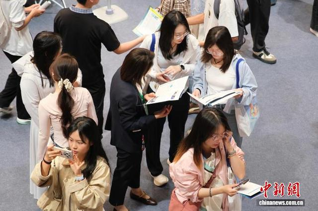 5月10日，求职者与企业方在交流。中新社记者 曹丹 摄