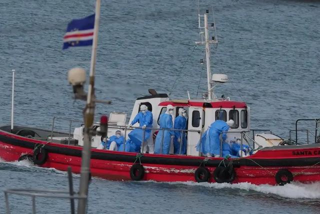 5月6日，在佛得角首都普拉亚港口，身着防护服的医务人员从“洪迪厄斯”号邮轮转运病患。新华社 图
