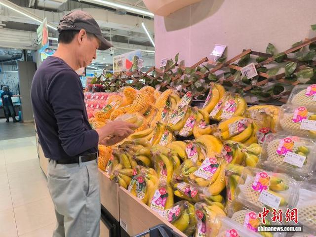 5月8日，重庆市两江新区一水果店内，顾客正在挑选进口香蕉。张旭 摄