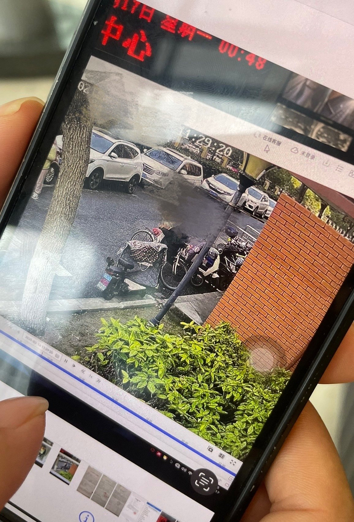 付佳丽手机中存着默默被父亲带走时，小区监控视频拍摄下的画面。新京报记者 张静姝摄