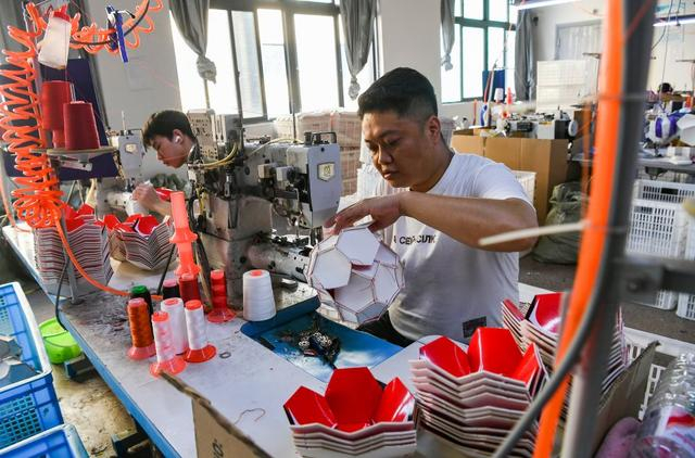 2025年9月15日，义乌一家体育用品公司的工人在赶制足球订单。新华社发（时宽兵摄）