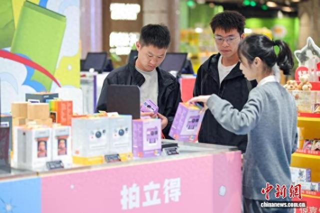 2025年12月2日，顾客在cdf海口国际免税城选购拍立得相机。中新社记者 骆云飞 摄