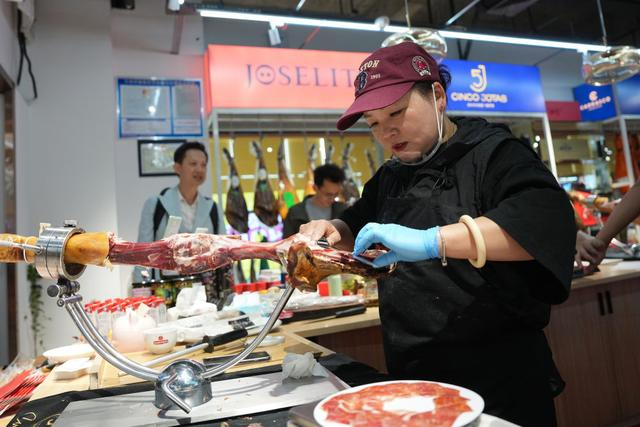 2026年3月30日，义乌国际商贸城一家进口商品店的店主在切西班牙伊比利亚火腿。新华社记者 黄宗治 摄