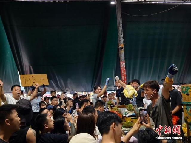 图为商户在用喝彩的方式吸引顾客购买榴莲。刘芷邑 摄