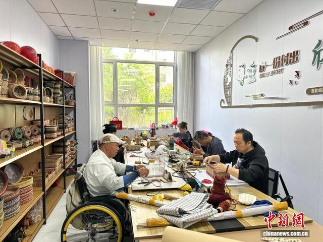 图为就业工坊内，残障人士正在进行手工编织工作。杨娜 摄