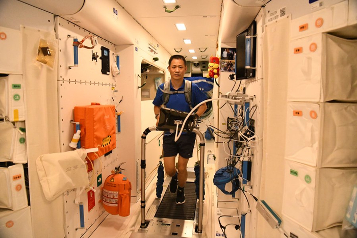 神舟十二号航天员聂海胜穿找空间运动服在空间站核心舱的太空跑台上锻炼身体