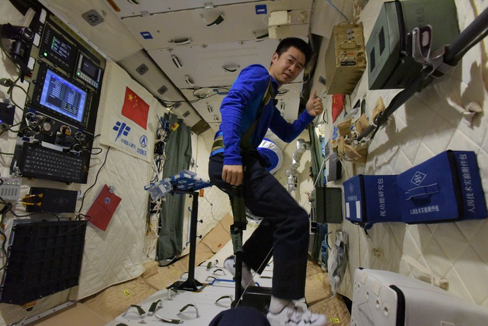 神舟十一号航天员陈冬在天宫二号内用没有把的太空自行车进行锻炼
