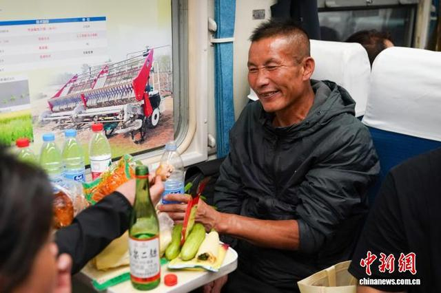 5月13日，黑龙江哈尔滨，插秧客在车厢内吃晚饭。赵宇航 摄