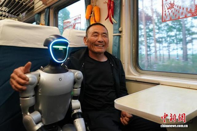 5月13日，黑龙江哈尔滨，车厢内人形机器人吸引插秧客。赵宇航 摄
