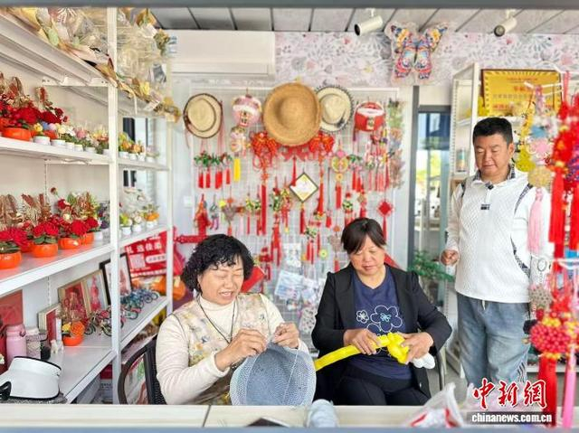 5月中旬，助残就业“爱心屋”内，三名残障人士制作手工艺品并交流经验。闫姣 摄