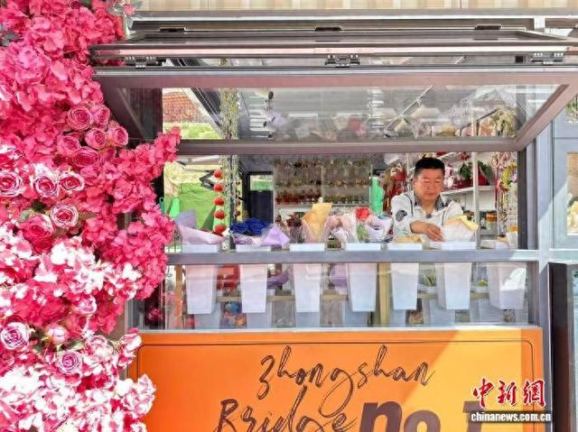 5月中旬，位于甘肃兰州市城关区中山桥附近的助残就业“爱心屋”内，残障人士黄应州整理摆放物品。闫姣 摄