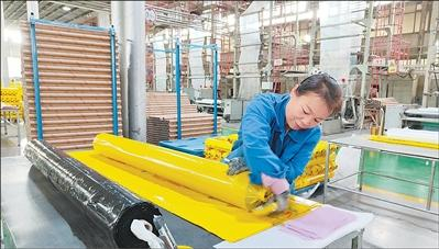 图为工作人员在厂房里打包地膜。