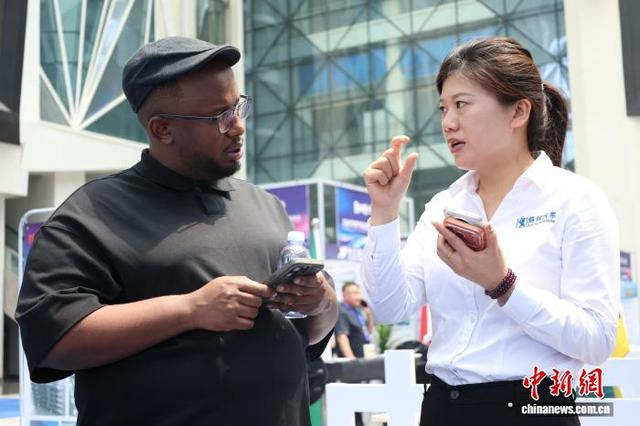 5月14日，山东济宁梁山县，海外采购商与中国展商交流专用汽车性能。周艺伟 摄