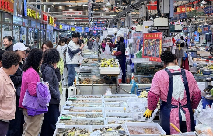 图为青岛团岛农贸市场内，消费者选购海鲜产品。