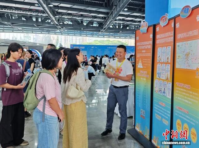 求职者现场了解相关政策。记者 邓霞 摄