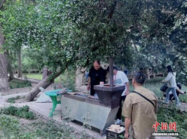 图为稻香村村民正在做美食招待游客。袁鹏冲 摄