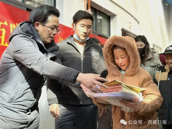 图为那曲市嘉黎县藏比乡美巴尔村驻村工作队员正为学生发放学习用品。