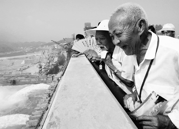 2005年7月1日，三峡大坝坝顶对游客开放，夷陵区陈家冲移民兄弟俩，登上坝顶观看泄洪，乐得合不拢嘴。